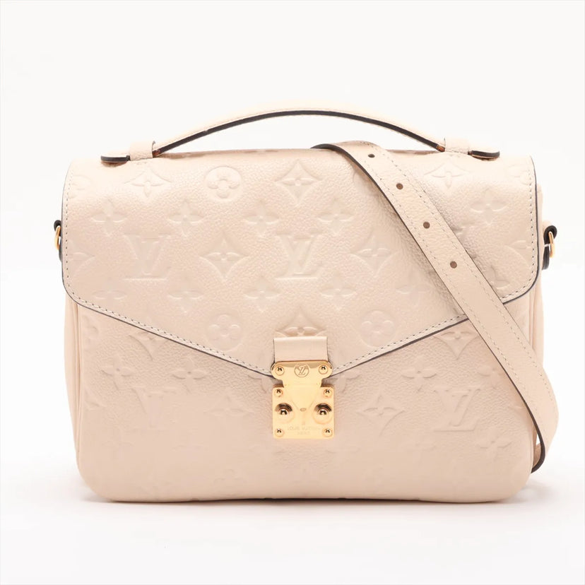 Louis Vuitton Pochette Métis i beige Monogram Empreinte-læder med guldfarvet lås, set forfra